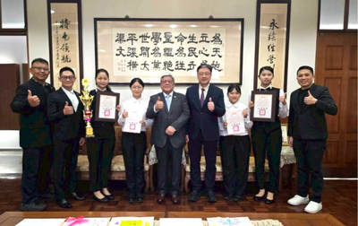 黃董事長與旅館系得獎同學合影，給予鼓勵圖片